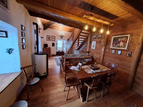 a dining room with a wooden table and chairs at La casa nell'airetta in Balme