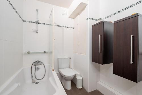 une salle de bain blanche avec toilettes et baignoire dans l'établissement Veeve - Fabulous on Faure, à Paris