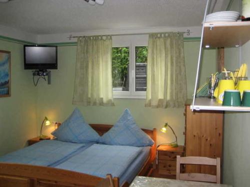 ein Schlafzimmer mit einem Bett mit blauen Kissen und einem Fenster in der Unterkunft Gästezimmer Sieg in Rust