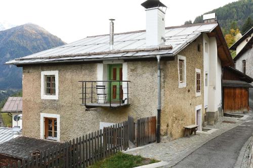 a brick house with a green door and a fence at Haus 59 Stilfs in Stelvio