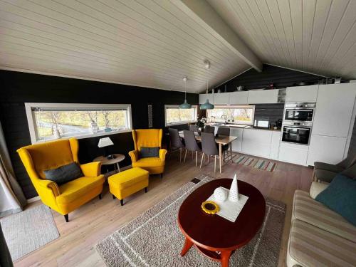 sala de estar con sillas amarillas y mesa en Flott hytte i Morfjorden, Laupstad, en Laupstad