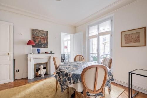 une salle à manger avec une table et des chaises et une cheminée dans l'établissement Veeve - Honeybee Soul, à Paris