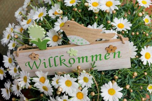 Una señal con la palabra Willomen en un ramo de flores en Haus Ohnemus Fam Späth, en Rust