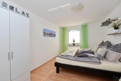 Schlafzimmer mit einem Bett mit grünen Vorhängen und einem Fenster in der Unterkunft Alte Schmiede in Franken Vorstadt