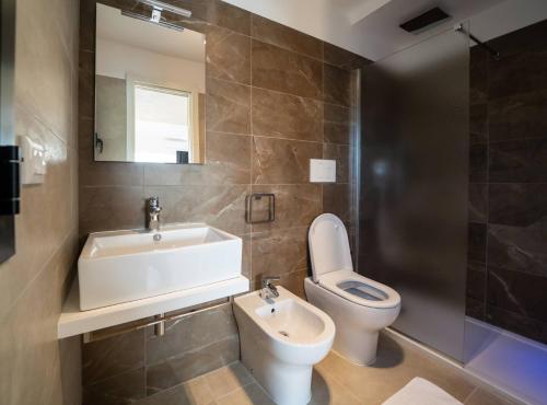 a bathroom with a sink and a toilet and a mirror at Village Lake Placid in Silvi Marina