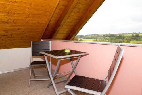 ein kleiner Tisch und zwei Stühle auf einem Balkon in der Unterkunft Ferienwohnung Storchenblick in Herbolzheim