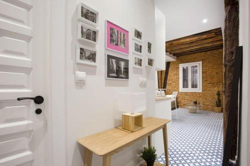 a room with white walls and a table with pictures on the wall at Etxeburu (Apto Casco Viejo) in Bilbao
