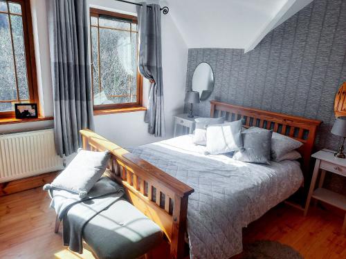 1 dormitorio con 1 cama y 1 silla en Knockmanagh Holiday Home, en Kilcummin