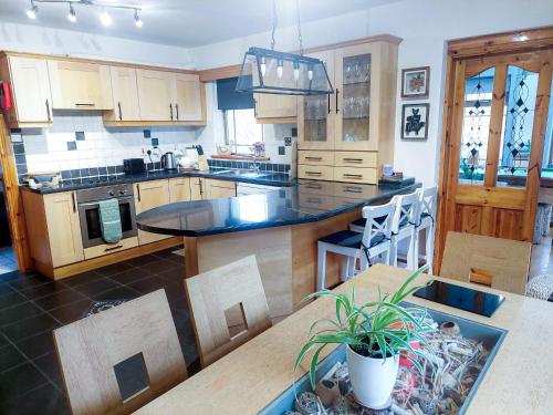una cocina con armarios de madera y una mesa con una maceta. en Knockmanagh Holiday Home, en Kilcummin