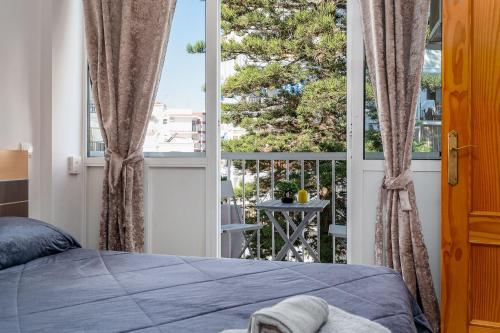 1 dormitorio con cama y ventana grande en Complejo Andalucía Torrecilla Beach, en Nerja