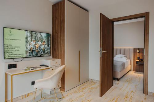 a room with a desk and a bed and a tv at Five Seasons Szklarska Poręba in Szklarska Poręba