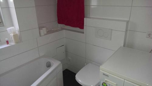 La salle de bains blanche est pourvue de toilettes et d'un lavabo. dans l'établissement Loft Nagoldtal 81 qm, à Pforzheim