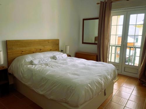 a bedroom with a large bed with a wooden headboard at Apartamento La Visera Plaza Andalucía in Sierra Nevada