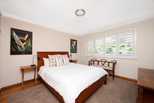 Un dormitorio con una cama grande y una ventana. en Vitamin Sea, en Mollymook