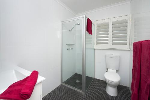 Un baño con inodoro y ducha de cristal. en Vitamin Sea, en Mollymook