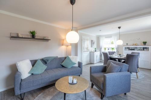 a living room with a couch and two chairs and a table at Jule Ahoi in Stedesand