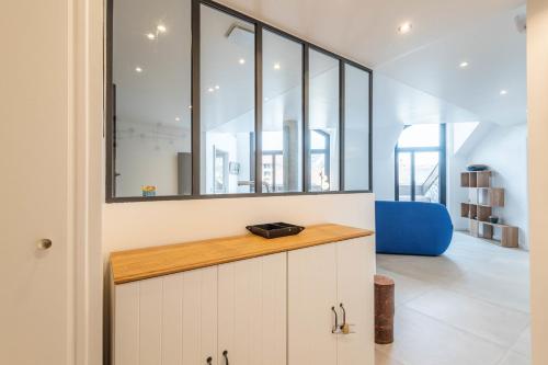 une cuisine avec des placards blancs et une chaise bleue dans l'établissement LA MANUFACTURE - Bel Appartement Contemporain en Coeur de ville, à Annecy