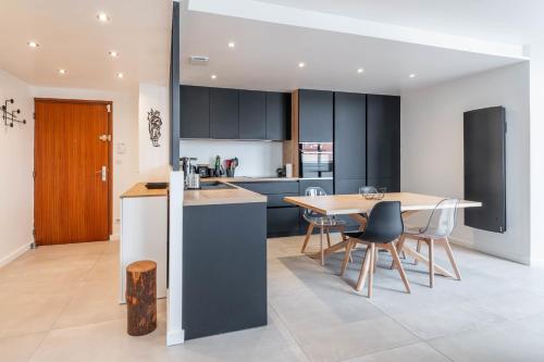 une cuisine et une salle à manger avec une table et des chaises dans l'établissement LA MANUFACTURE - Bel Appartement Contemporain en Coeur de ville, à Annecy