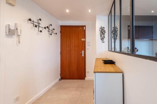 - une cuisine avec un comptoir et une porte en bois dans l'établissement LA MANUFACTURE - Bel Appartement Contemporain en Coeur de ville, à Annecy