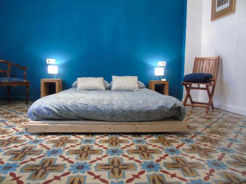 1 dormitorio con cama y pared azul en Ca la Rosa, en La Font D´En Carròs