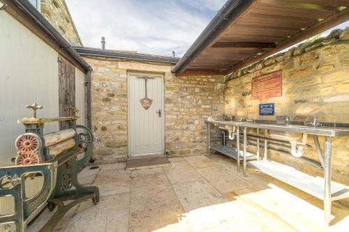 een kamer met een stenen muur met een deur en een tafel bij Wharfe Pod in Kettlewell