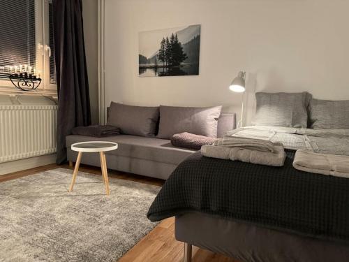ein Wohnzimmer mit einem Bett und einem Sofa in der Unterkunft Lägenhet i centrala Lidköping - MyHostel in Lidköping