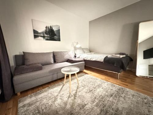 een woonkamer met een bank en een tafel bij Lägenhet i centrala Lidköping - MyHostel in Lidköping