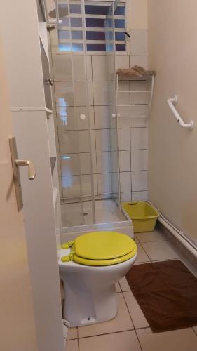 a bathroom with a toilet with a yellow lid at La villa du manguier in Le Vauclin