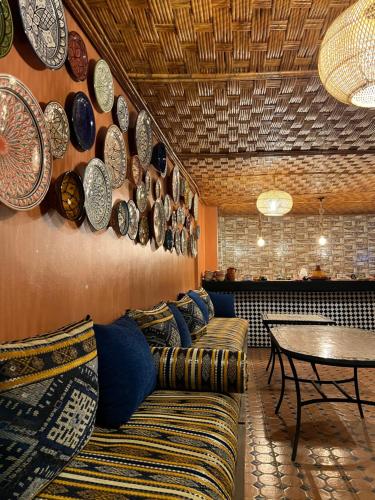 a living room with couches and plates on the wall at Riad el wazania in Rabat