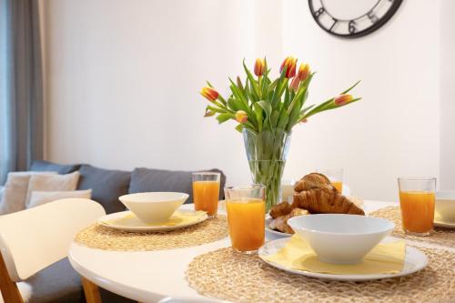 a table with a vase of flowers and orange juice at U Zlaté hvězdy Ritz in Litoměřice