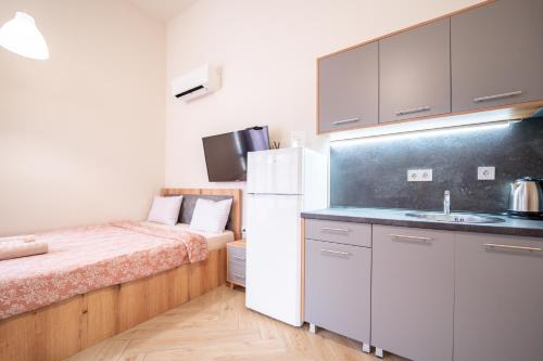 a small kitchen with a bed and a refrigerator at WOW studios for rent - bul Montevideo 25A - B in Sofia