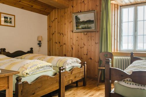 1 dormitorio con 2 camas y ventana en Hotel Chasseral en Nods