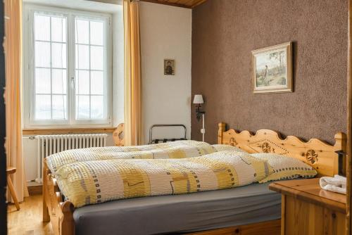 1 dormitorio con cama y ventana en Hotel Chasseral, en Nods
