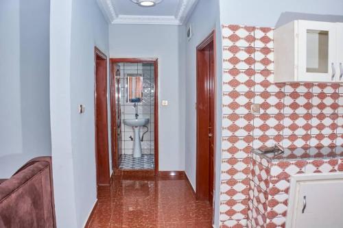 a hallway with a bathroom with a sink and a mirror at Becky Best Apartments in Limbe
