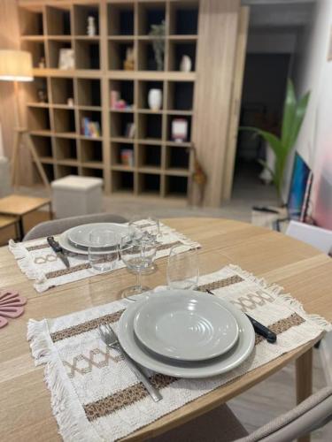 une table avec des assiettes et des verres à vin dessus dans l'établissement Appartement - Vielle ville, à Grasse