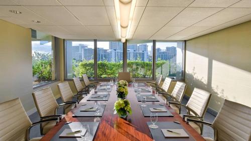 a long dining room with a long table and chairs at Ka Laʻi Waikiki Beach, LXR Hotels & Resorts in Honolulu