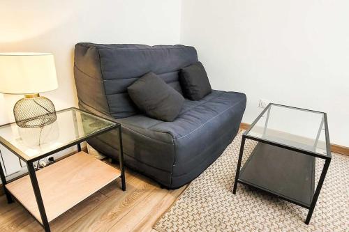 un salon avec un canapé bleu et une table en verre dans l'établissement Le Chopin A côté de la gare, à Nancy