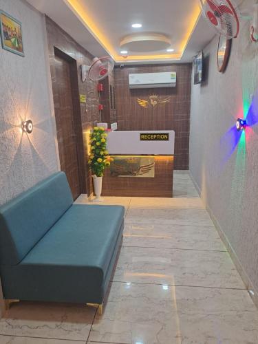 een lobby met een blauwe bank in een kamer bij Hotel Lake Palace By G L Group in Ahmedabad