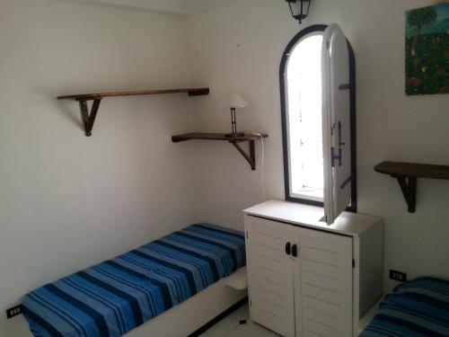 Un dormitorio pequeño con una cama y una ventana. en Villa Jeko, en Lampedusa