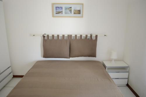 a bedroom with a bed with a pillow and a nightstand at Appartamenti Le Spiagge in Marciana Marina