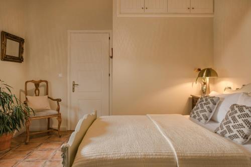 a bedroom with a bed and a chair and a door at Scorpios Mansion Loft / Downtown Skala / Seaside in Skala Kefalonias