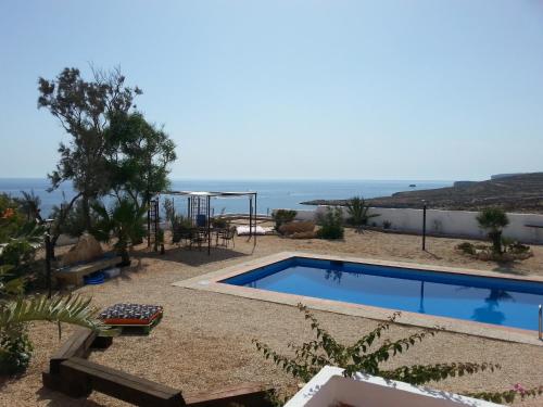 a swimming pool with a view of the ocean at Villa Jeko in Lampedusa