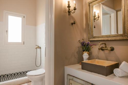 a bathroom with a sink and a toilet and a mirror at Scorpios Mansion Loft / Downtown Skala / Seaside in Skala Kefalonias