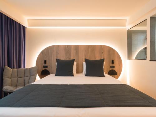 1 dormitorio con 1 cama grande y 1 silla en Sercotel Playa Canteras en Las Palmas de Gran Canaria