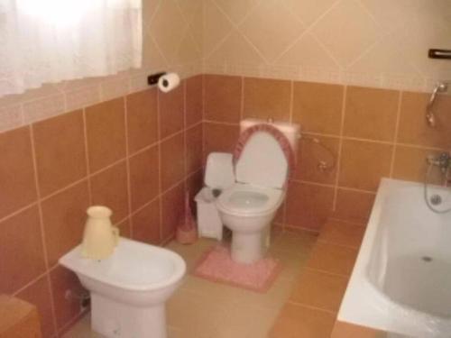 ein Badezimmer mit einem WC, einem Waschbecken und einer Badewanne in der Unterkunft Férias na Praia do Tofo, relaxantes e únicas in Praia do Tofo