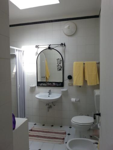 a bathroom with a sink and a toilet and a mirror at Villa Jeko in Lampedusa
