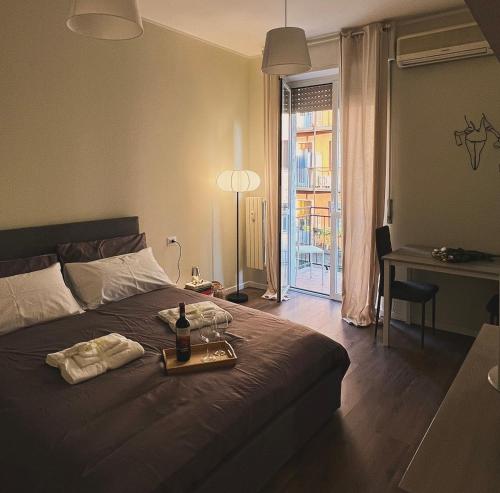 Schlafzimmer mit einem Bett und einem Tablett mit einer Flasche Wein in der Unterkunft Lawyer House Milan in Mailand