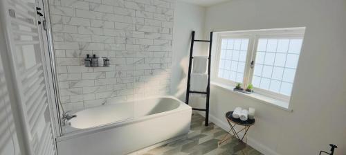 a white bath tub in a bathroom with a window at Hampshire Charming House in Lincoln