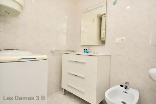 a white bathroom with a sink and a toilet at Las Damas 3B Beach Front - Pool & Parking in Benidorm
