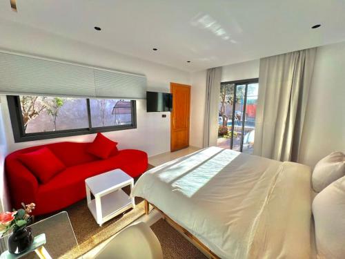 um quarto com uma cama vermelha e um sofá vermelho em Villa Alambra Marrakech sur Atlas, Piscine privée em Marrakech
